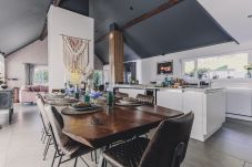 Teignmouth self-catering holiday home. Open-plan living area with vaulted ceilings, modern kitchen, and dining table for 12.